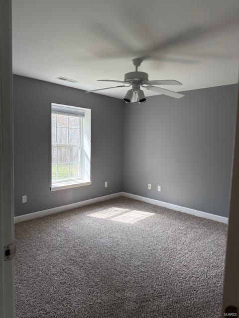 spare room featuring carpet flooring, baseboards, visible vents, and ceiling fan