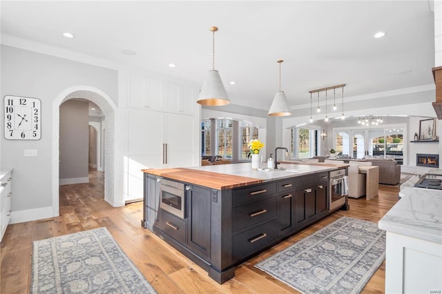 kitchen featuring stainless steel appliances, a large island, open floor plan, and white cabinetry