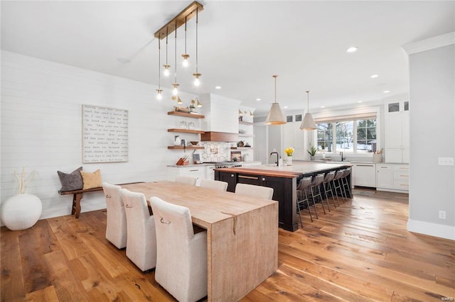 dining space with recessed lighting, crown molding, and light wood-type flooring