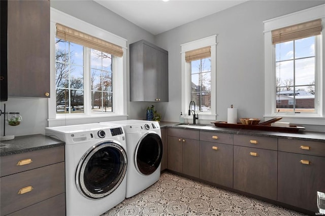 washroom with washer and clothes dryer, cabinet space, and a sink