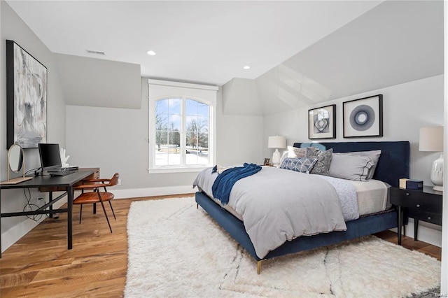 bedroom with recessed lighting, baseboards, lofted ceiling, and wood finished floors