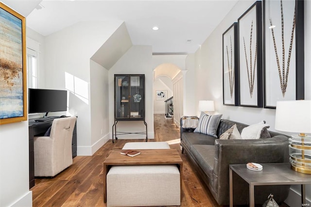 living room with recessed lighting, wood finished floors, arched walkways, and baseboards