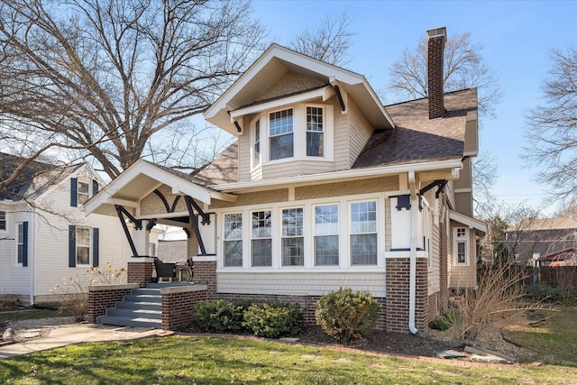 view of front of house featuring covered porch, roof with shingles, and a chimney