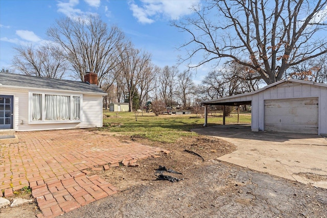 view of yard with a detached garage and an outbuilding