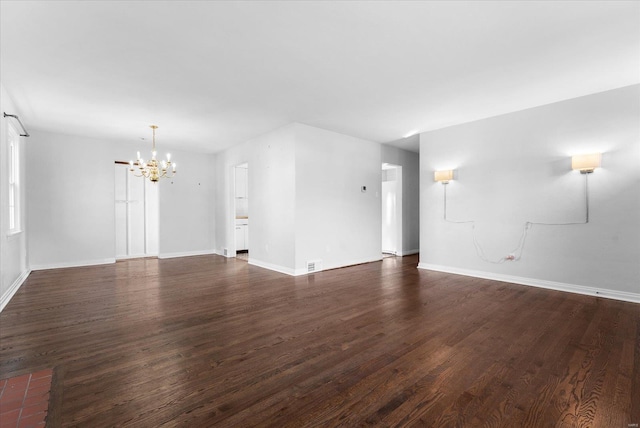 unfurnished living room with dark wood-type flooring, visible vents, baseboards, and a chandelier