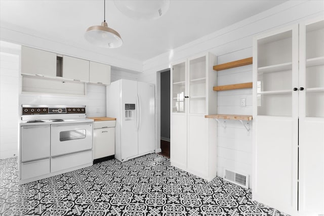 kitchen with visible vents, white appliances, white cabinets, and butcher block counters