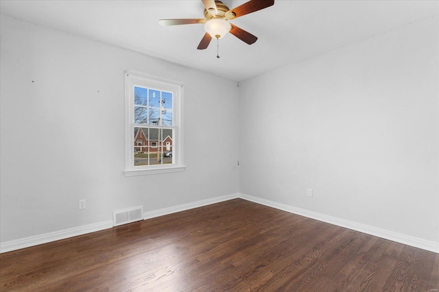 empty room with a ceiling fan, wood finished floors, visible vents, and baseboards