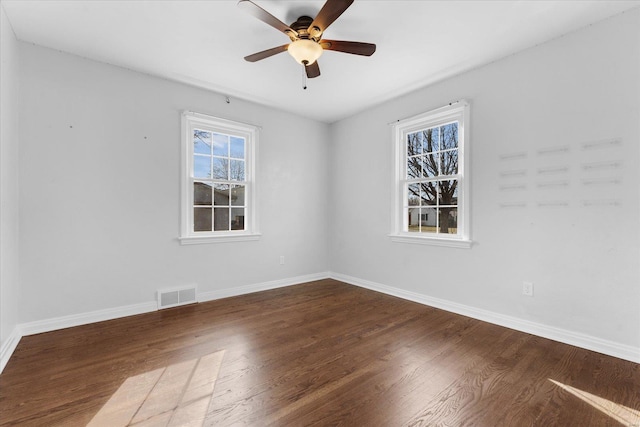 unfurnished room with ceiling fan, visible vents, baseboards, and wood finished floors