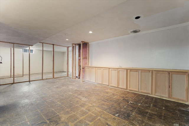 below grade area featuring recessed lighting, visible vents, and ornamental molding