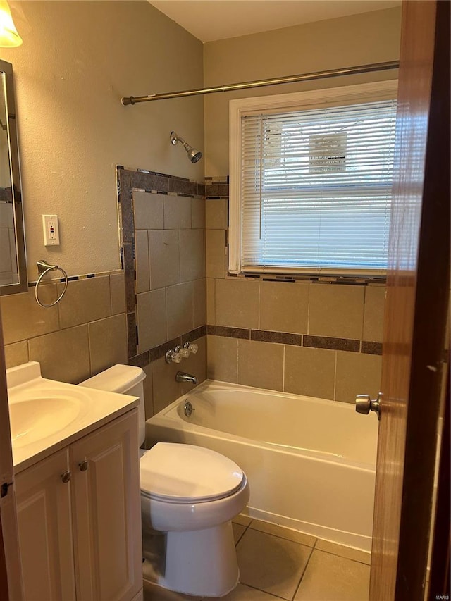 full bath featuring vanity, tile patterned floors, tile walls, toilet, and shower / bathtub combination