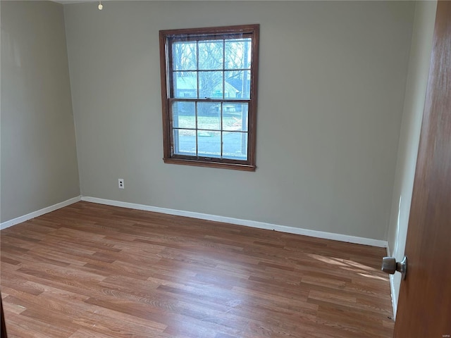 unfurnished room featuring baseboards and wood finished floors