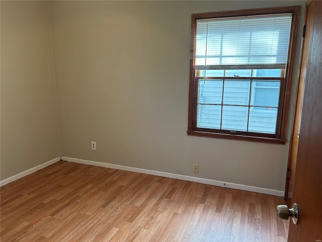 spare room featuring light wood-style flooring and baseboards