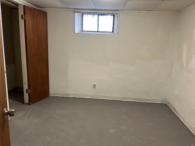 basement featuring baseboards and a drop ceiling