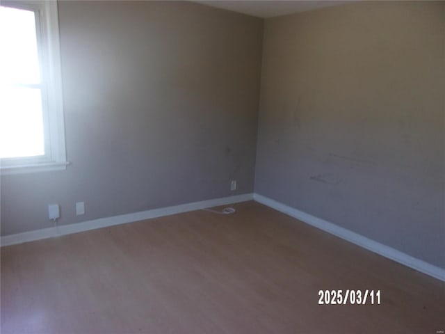 empty room featuring wood finished floors and baseboards