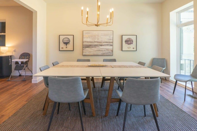 dining area with baseboards, an inviting chandelier, and wood finished floors