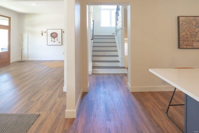 staircase featuring wood finished floors and baseboards