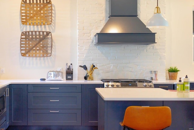 kitchen with premium range hood, blue cabinetry, decorative backsplash, light countertops, and stove