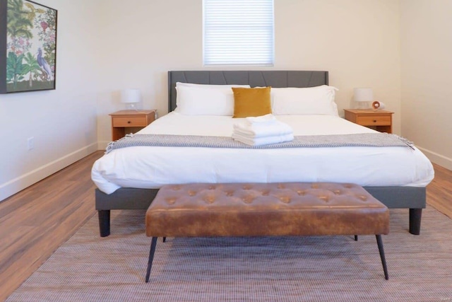 bedroom with baseboards and wood finished floors