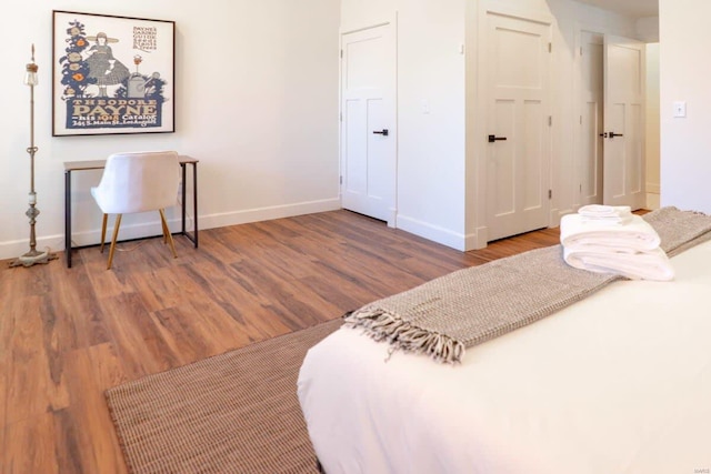 bedroom with a closet, baseboards, and wood finished floors