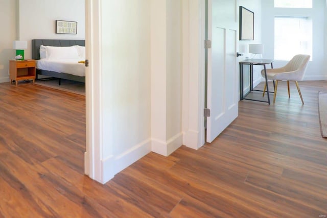 hallway with baseboards and dark wood-type flooring