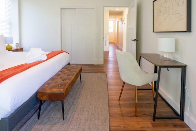 bedroom with a closet, multiple windows, and wood finished floors