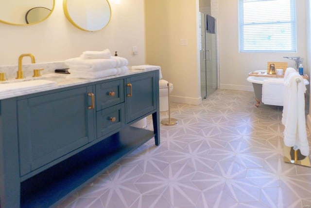 bathroom with baseboards, toilet, a stall shower, tile patterned floors, and vanity