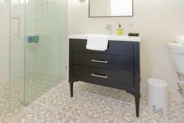 bathroom featuring vanity, baseboards, a stall shower, tile patterned floors, and toilet