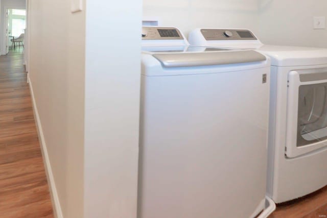 washroom featuring wood finished floors, washing machine and dryer, and laundry area