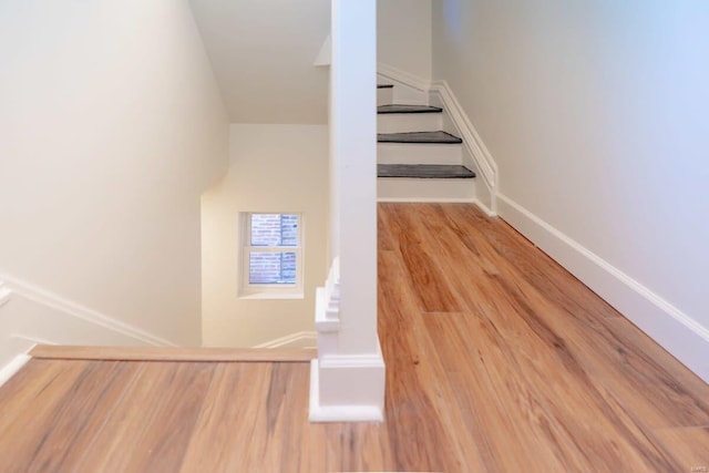 staircase with baseboards and wood finished floors