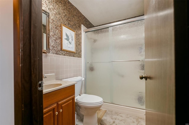 full bath with toilet, tile walls, a shower stall, wallpapered walls, and vanity