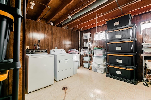 laundry area featuring laundry area, tile patterned floors, separate washer and dryer, and wood walls