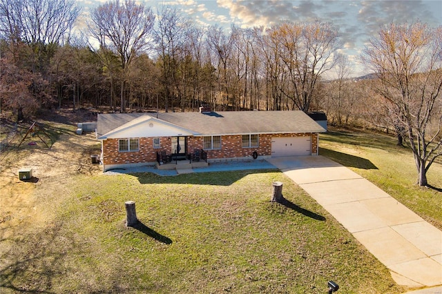 ranch-style house with brick siding, an attached garage, concrete driveway, and a front lawn