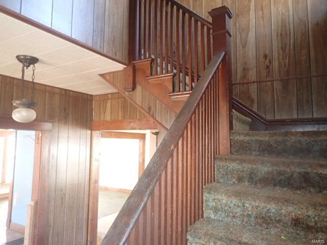 stairs featuring wood walls