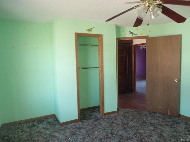 unfurnished bedroom with baseboards, a closet, ceiling fan, and carpet