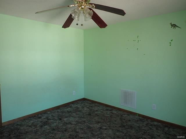 unfurnished room featuring baseboards, a ceiling fan, visible vents, and carpet