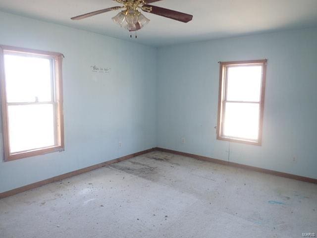 empty room featuring baseboards and ceiling fan
