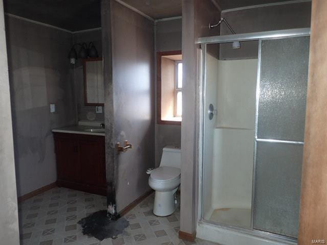 bathroom featuring a shower stall, baseboards, toilet, and vanity