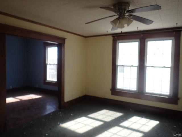 unfurnished room featuring plenty of natural light, crown molding, baseboards, and ceiling fan