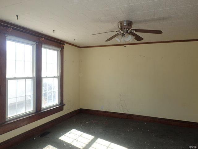 unfurnished room featuring baseboards, crown molding, and a ceiling fan