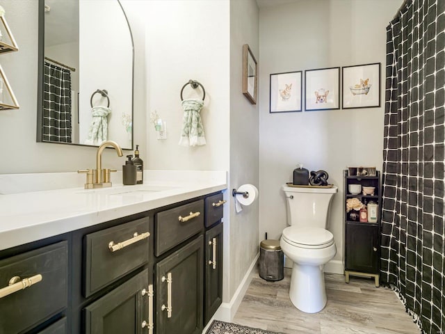 bathroom featuring a shower with shower curtain, toilet, vanity, and wood finished floors