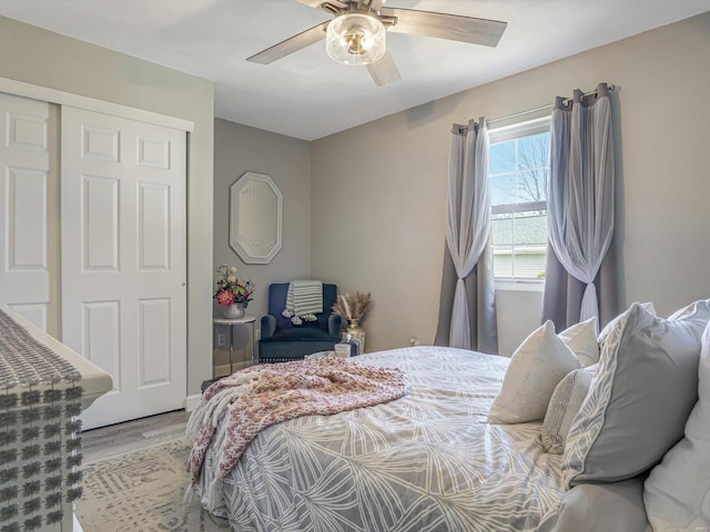 bedroom featuring a ceiling fan, wood finished floors, and a closet