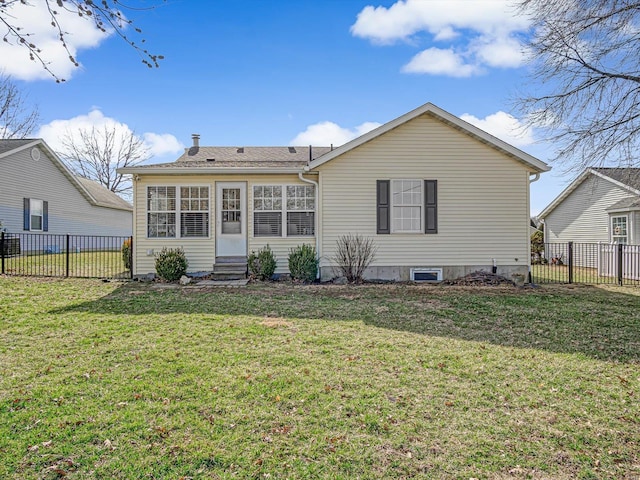 rear view of house with entry steps, a lawn, and a fenced backyard