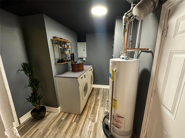 utility room with water heater, washer and dryer, and electric panel