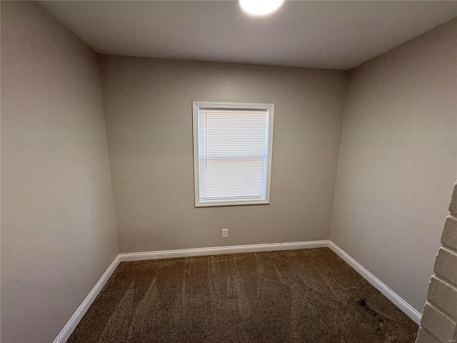 carpeted empty room featuring baseboards