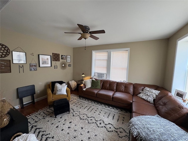 living room with wood finished floors, baseboards, and ceiling fan