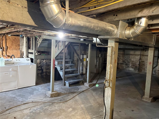 unfinished basement with stairway, separate washer and dryer, and water heater