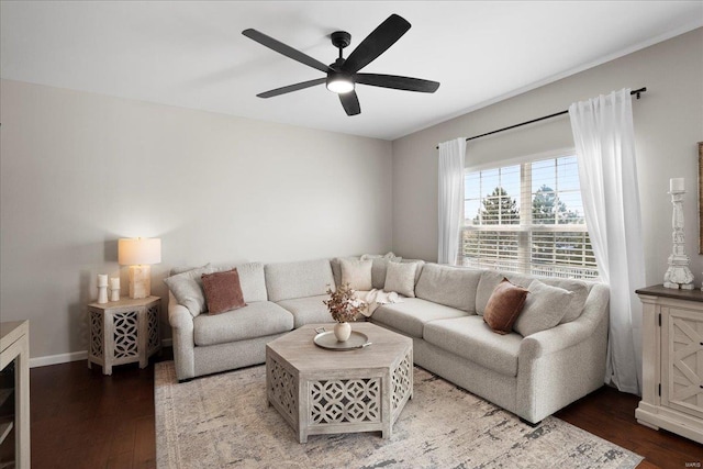 living area with a ceiling fan, wood finished floors, and baseboards