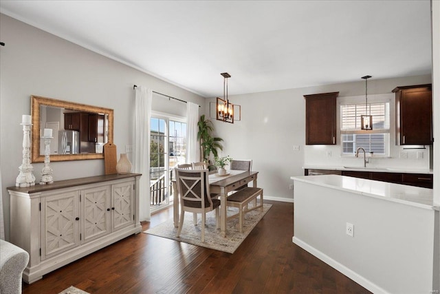 dining room featuring a notable chandelier, dark wood-style floors, and baseboards