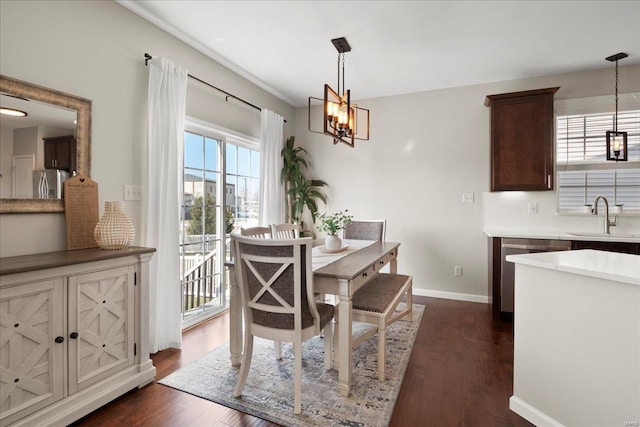 dining space featuring baseboards, a notable chandelier, and dark wood-style flooring