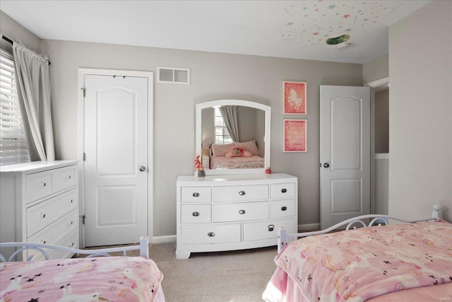 bedroom featuring visible vents, light colored carpet, and baseboards